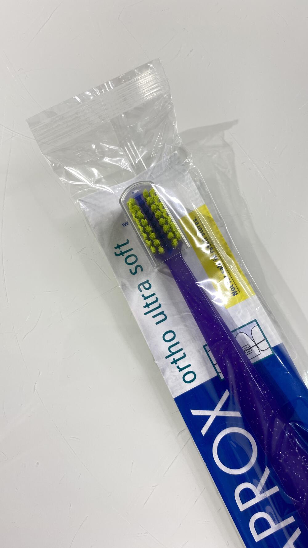 Ортодонтична зубна щітка з поглибленням для брекет систем у поліетилені фіолетовий з салатним Curaprox 